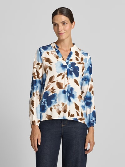 Frauenmodel trägt Relaxed Fit Bluse aus reiner Viskose Modell 'Lari' von ZABAIONE mit blau-braunem Muster, Ganzkörperansicht von vorne. Damen Bluse, Serafino-Ausschnitt, langärmelig, Rückenlänge 55 cm, Ärmellänge 57 cm.