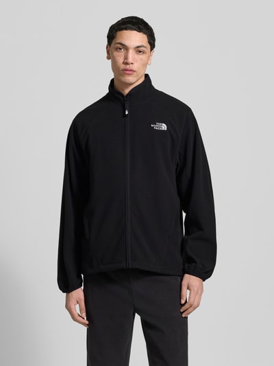 Mannenmodel draagt Fleecejacke mit Label-Stitching van The North Face, regular fit, opstaande kraag, rits, zwart, vooraanzicht bovenlichaam.