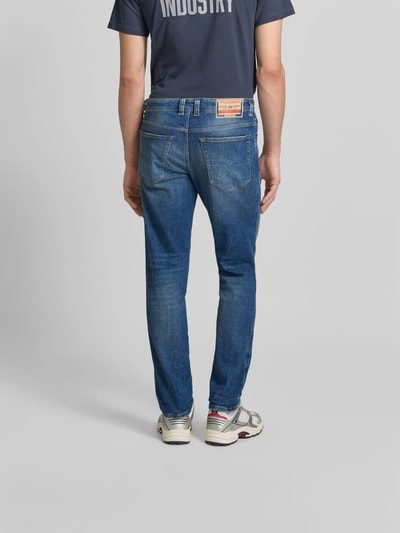 Männermodel trägt Straight Fit Jeans aus Baumwoll-Mix von Diesel, blaue Waschung, 5-Pocket-Design, Label-Detail, Ganzkörperansicht Rückansicht.