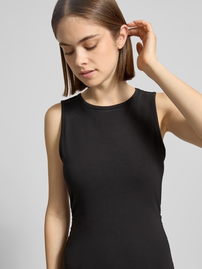 Frauenmodel trägt Top mit Rundhalsausschnitt Modell 'MOLLY' von Noisy May, schwarzer Baumwoll-Elasthan-Mix, Slim-Fit, Label-Detail, Rückenlänge 52 cm bei Größe S, Nahaufnahme Oberkörper.