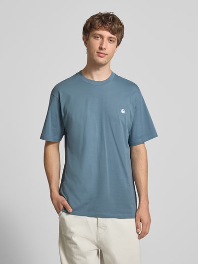 Männermodel trägt Herren T-Shirt mit Label-Stitching Modell 'Madison' von Carhartt Work In Progress aus Reine Baumwolle, Regular-Fit, Rundhalsausschnitt, Rückenlänge bei Größe M 75 cm, Ganzkörperansicht von vorne.