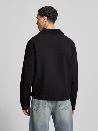 Männermodel trägt Regular Fit Ranch-Jacke aus reiner Baumwolle von Tommy Jeans in Schwarz, Umlegekragen aus Cord, Ganzkörperansicht Rückansicht.