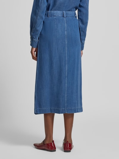 Frauenmodel trägt Jeansrock mit Knopf- und Reißverschluss Modell 'SATOVES' von Samsøe Samsøe, A-Linie, reine Lyocellstruktur, Midirock, Ganzkörperansicht Rückansicht.