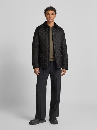 Męski model nosi Kurtka pikowana z wykładanym kołnierzem od Barbour, krój regular fit, jednokolorowy, listwa z zatrzaskami, wpuszczane kieszenie, wyhaftowane logo, pikowanie, długość tyłu 68 cm, szerokość ramion 40 cm, szerokość klatki piersiowej 42 cm, długość rękawów 70 cm, widok całej sylwetki od przodu.