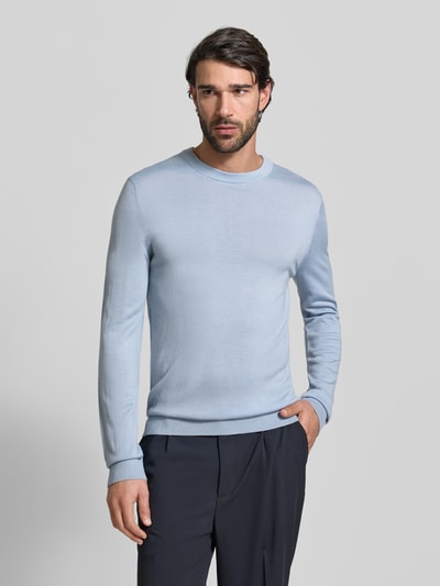 Männermodel trägt Regular Fit Pullover aus reiner Wolle Modell 'TRAY' von SELECTED HOMME in Hellblau, Feinstrick, Ganzkörperansicht von vorne.