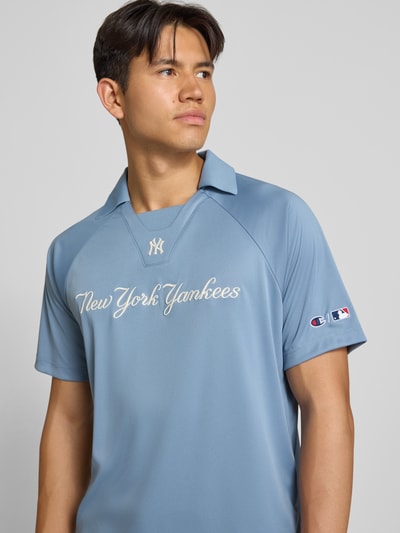 Męski model nosi Relaxed Fit Poloshirt mit Logo-Stitching od Champion, niebieski odcień, wyhaftowane logo, kołnierzyk polo, krótki rękaw, długość tyłu w rozmiarze M: 70 cm, z przodu widok na górną część ciała.