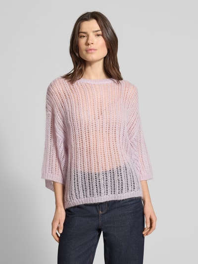 Frauenmodel trägt Relaxed Fit Wollpullover aus Mohair-Mix Modell 'C_FRUG' von BOSS Orange in Hellviolett, grob gestrickt, unifarben, Crew Neck, halblange Ärmel, gerippte Abschlüsse, Ganzkörperansicht von vorne.