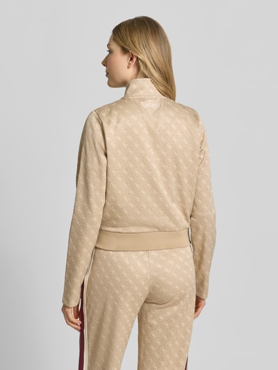 Frauenmodel trägt Regular Fit Sweatjacke mit Allover-Logo-Print Modell 'Jacquard' von Guess Activewear, beige, elastischer Bund, Material-Mix, Ganzkörperansicht Rückansicht.