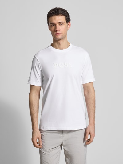 Männermodel trägt Regular Fit T-Shirt aus reiner Baumwolle Modell 'TS_TERRACE' von BOSS Green, unifarben, 3D-Label Print, Nahaufnahme Oberkörper.