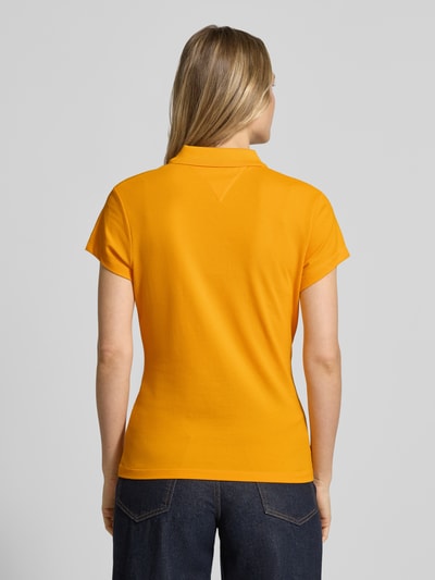 Vrouwenmodel draagt Slim Fit poloshirt uit katoenmix van Tommy Hilfiger, look: effen, piqué, gestikt logo, korte mouw, geheel achteraanzicht.