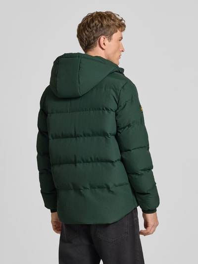 Männermodel trägt Jacke mit Kapuze Modell 'CLASSIC EVEREST' von Superdry in Dunkelgrün, gerade Steppung, Rückenansicht, Ganzkörperansicht Rückansicht. Gerader Schnitt, Kapuze mit Kordelzug, Reiß- und Druckknopfverschluss, Label-Patch, seitliche Eingrifftaschen, Ärmelriegel mit Druckknopf. Rückenlänge 75 cm, Schulterbreite 47 cm, Brustweite 58 cm, Ärmellänge 71 cm.