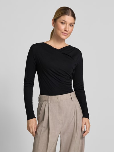 Frauenmodel trägt Longsleeve aus Lyocell-Mix in Wickel-Optik von windsor., schwarz, schmal geschnitten, Label-Detail, Nahaufnahme Oberkörper.