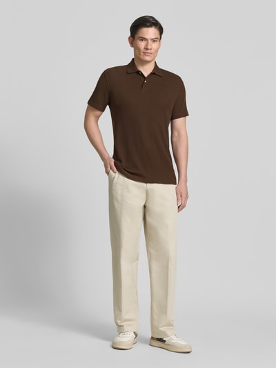 Männermodel trägt Regular Fit Poloshirt aus Baumwoll-Mix Modell 'BLAZE' von SELECTED HOMME, unifarben braun, Ganzkörperansicht von vorne.