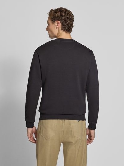Männermodel trägt Regular Fit Sweatshirt aus reiner Baumwolle mit Label-Patch von Scotch & Soda, schwarze Farbe, elastische Abschlüsse, Kontext Herren Sweatshirt, Rückansicht, Ganzkörperansicht Rückansicht.