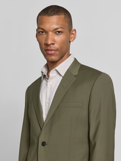 Männermodel trägt Sakko mit Woll-Anteil und Label-Patch Modell 'Jamie' von Tiger Of Sweden im Regular-Fit, Material-Mix, Reverskragen, Knopfverschluss, Brustleistentasche, Pattentaschen, Nahaufnahme Oberkörper.