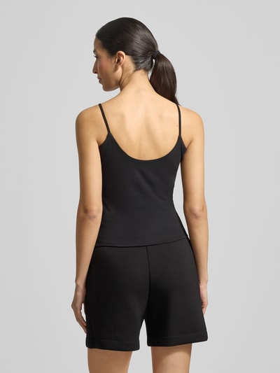 Frauenmodel trägt Trägertop mit Logo Modell 'ORTENSIA' von Guess Activewear aus Baumwoll-Elasthan-Mix, Rückansicht, Ganzkörperansicht.