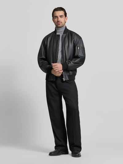Mannelijk model draagt Weite Hos met Viskose-Anteil Modell 'RIKO261' van HUGO in zwart, regular fit, unicolor, met riemlussen, label patch, zijdelingse steekzakken, schuihaaksluiting en blinde ritssluiting, voorkantaanzicht op volledige lichaamslengte.