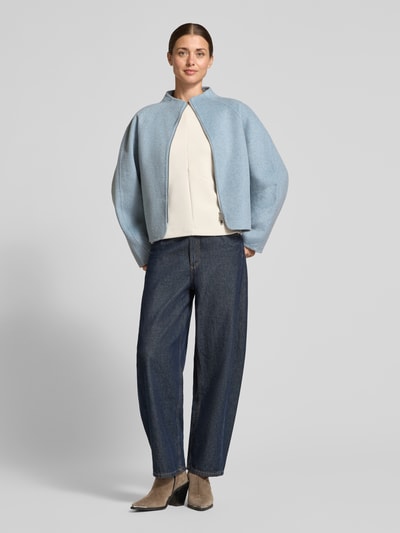 Kobiece model prezentuje Relaxed Fit Kurzmantel Modell 'Helisu' od OPUS, kolor jednolity matowy, struktura filcu, stebnowany kołnierz typu stójka, zapięcie na zamek, długie raglanowe rękawy, zaokrąglone wykończenie dołu, materiał z mieszanki wełny, widok całej sylwetki z przodu.