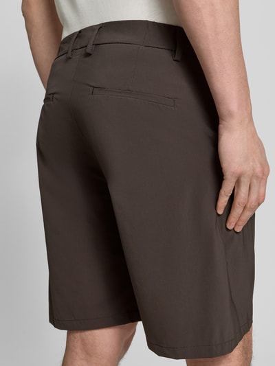Mężczyznamodel nosi szorty z kieszeniami z tyłu Shorts mit Gesäßtaschen Modell 'Yasan' od Drykorn, mieszanka materiałów z dodatkiem streczu, krój regular fit, kolor ciemnobrązowy, długość wewnętrzna nogawki 23 cm, szerokość w rozmiarze 32: 44 cm, tył, zbliżenie na dolną część pleców.