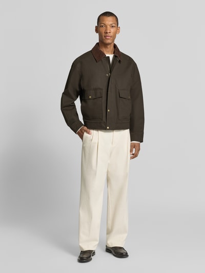 Männermodel trägt Regular Fit Blouson aus reiner Baumwolle Modell 'MONTANA' von Selected in Dunkelbraun mit Umlegekragen, Ganzkörperansicht von vorne.