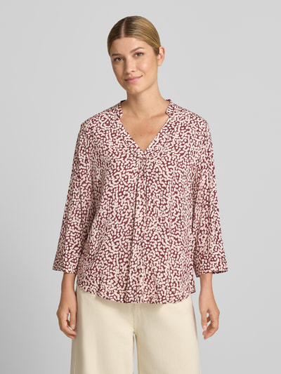Frauenmodel trägt Bluse aus reiner Viskose Modell 'Adney' von FREE/QUENT, lockere Passform, V-Ausschnitt, 3/4-Arm, creme-rote Muster, Ganzkörperansicht von vorne.