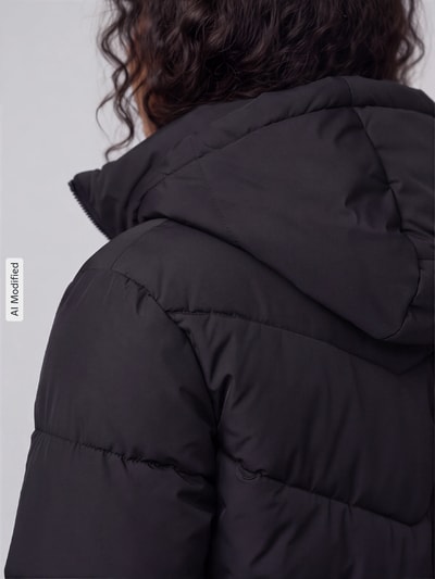 Frauenmodel trägt Regular Fit Steppjacke mit Kapuze Modell 'CLAIR' von ONLY, schwarze Farbe, glatte Oberfläche, Nahaufnahme Rücken, Damen Steppjacke von ONLY, KI-modifiziertes Bild.