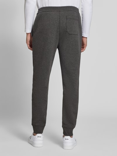 Männermodel trägt dunkelgraue Loose Fit Sweathose mit Logo-Stitching Modell 'MESH FACE' von Polo Ralph Lauren, Ganzkörperansicht Rückansicht.