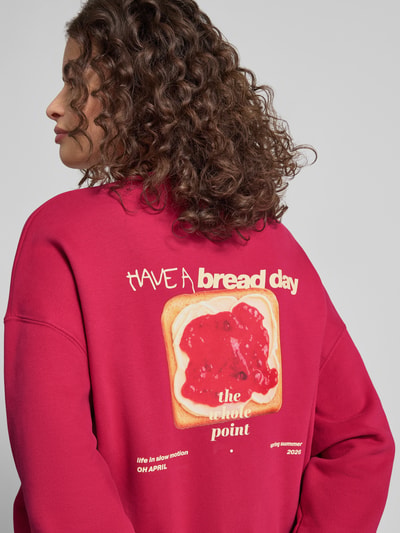 Frauenmodel trägt Oversized Sweatshirt mit Logo-Stitching Modell 'Toast' von OH APRIL in Rot, Baumwoll-Mix, Rückenansicht, Nahaufnahme Oberkörper.