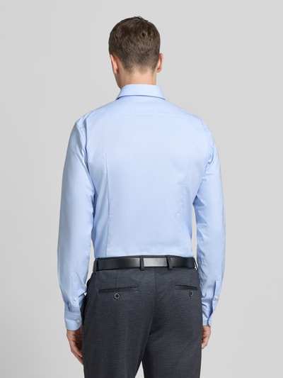 Męski model nosi Regular Fit Businesshemd mit extra langem Arm od BOSS, jasnoniebieska bawełna, krój regular fit, widok całej sylwetki z tyłu.