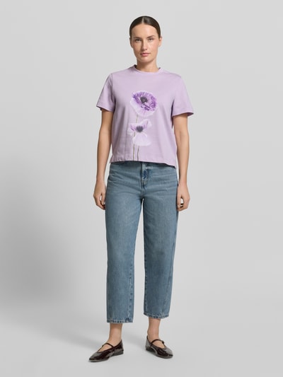 Kobiece modelka nosi T-Shirt mit Motiv-Print Modell 'FIORE' od Stefanel, czysta bawełna, krój regular fit, okrągły dekolt, długość tyłu w rozmiarze S: 55 cm, przedni widok całej sylwetki.