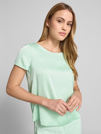 Frauenmodel trägt Blusenshirt mit Rundhalsausschnitt und abgerundetem Saum von Rinascimento in Mintgrün, Material-Mix, Nahaufnahme Oberkörper.