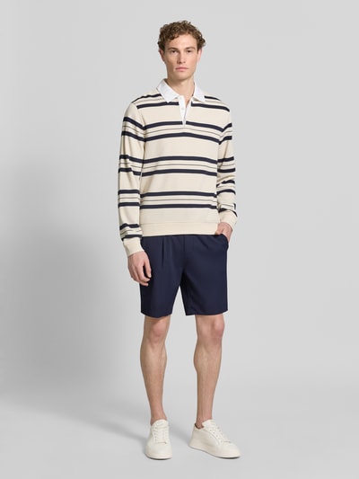 Männermodel trägt Pantalaccio Fit Bermudas mit Eingrifftaschen von MARKUP in Dunkelblau, Material-Mix mit Stretch-Anteil, Ganzkörperansicht von vorne. Bundweite 41 cm, Innenbeinlänge 21 cm, Paspeltaschen am Gesäß, Größe 50.