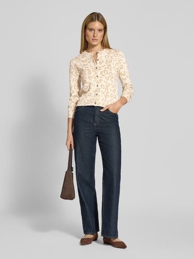 Frauenmodel trägt Regular Fit Cardigan mit Viskose-Anteil Modell 'Mayas' von Vila in Beige mit Allover-Animal-Stitching, Rundhalsausschnitt, Knopfleiste, Ganzkörperansicht von vorne.