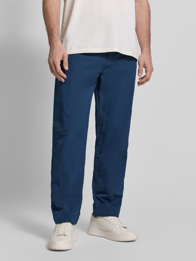 Männermodel trägt Straight Fit Chino mit integriertem Gürtel Modell 'STRAIGHT-7' von BOSS Orange, unifarben, Ganzkörperansicht von vorne.