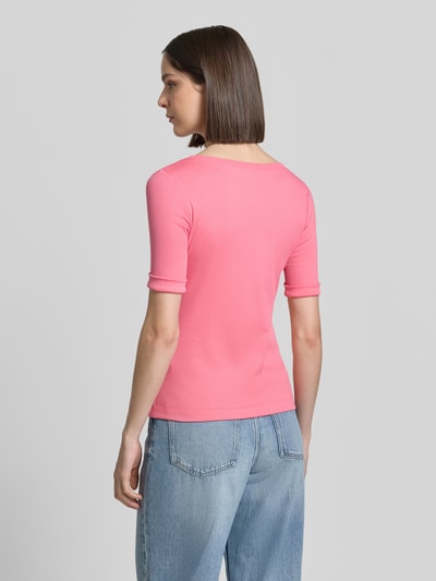 Modelka prezentuje damski t-shirt Marc Cain z mieszanki bawełny i elastanu, krój slim fit, okrągły dekolt, rękaw o dł. 1/2, długość tyłu w rozmiarze 36: 56 cm, różowy kolor, gładka tekstura, widok całej sylwetki z tyłu.
