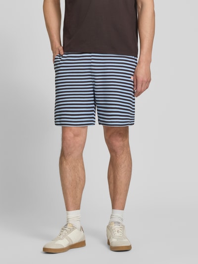Männermodel trägt Regular Fit Sweatshorts aus Baumwoll-Mix von Lacoste mit Optik:Allover-Muster, gestreift, Logo-Stitching, Ganzkörperansicht von vorne.