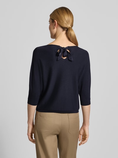 Männermodel trägt Relaxed Fit Pullover aus Viskose-Mix in Strick-Optik von comma, ciemnogranatowy kolor, 3/4 rękaw, elastyczne wykończenia, U-kształtny dekolt, długość tyłu 47 cm w rozmiarze 36, długość rękawa 45 cm, spokojna tekstura, widok całej sylwetki z tyłu.