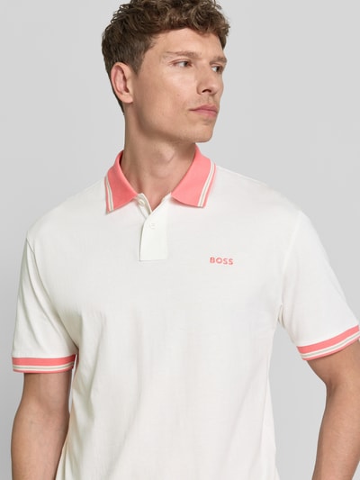 Männermodel trägt Regular Fit Poloshirt aus reiner Baumwolle Modell 'BLOCKS' von BOSS Orange, Optik: Unifarben, Nahaufnahme Oberkörper. Reine Baumwolle, Piqué, 2-Knopf-Verschluss, Polokragen, Ärmelform: Kurzarm, Label-Stitching-Applikation.