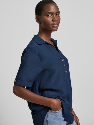 Frauenmodel trägt Relaxed Fit Bluse aus Viskose-Mix mit Umlegekragen von Apricot in Dunkelblau, Semitransparent, Knopfleiste, Halbarm, verlängerte Rückseite, Rückenlänge 81 cm, Ärmellänge 28 cm, Ganzkörperansicht von vorne.
