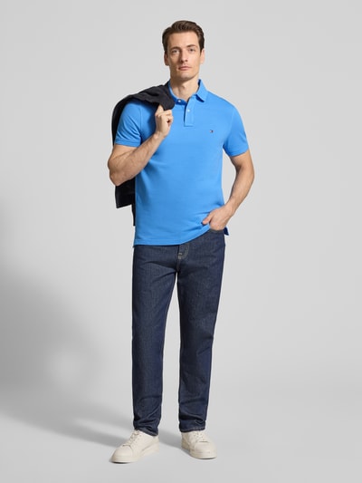 Männermodel trägt Regular Fit Poloshirt aus Baumwoll-Mix von Tommy Hilfiger, Optik: Unifarben, Logo-Stitching, Ganzkörperansicht von vorne.