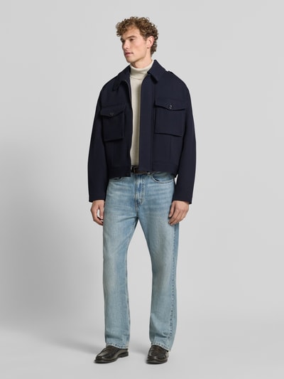 Männermodel trägt Jacke aus Viskose-Mix von Emporio Armani in Dunkelblau, gerade Passform, Umlegekragen, Ganzkörperansicht von vorne. Rückenlänge 64 cm, Schulterbreite 54 cm, Brustweite 64 cm, Ärmellänge 66 cm.