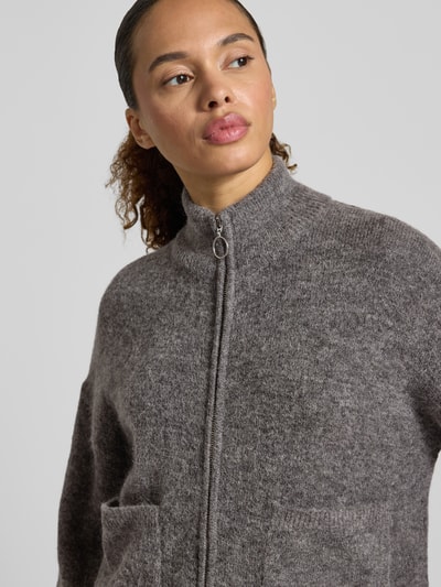 Vrouwenmodel draagt Regular Fit Strickjacke aus Woll-Mix Modell 'SIA' van Selected Femme in gemêleerd grijs, textuur zichtbaar, close-up bovenlichaam.
