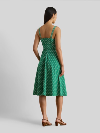 Frauenmodel trägt tailliertes Freizeitkleid aus reiner Baumwolle von Lauren Ralph Lauren mit grün-weißem Allover-Streifenmuster, Midi-Länge, breiten Trägern, Bindeband und geradem Saum, Ganzkörperansicht Rückansicht.