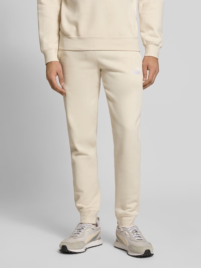 Männermodel trägt Sweatpants mit Label-Stitching von PUMA PERFORMANCE, Baumwoll-Mix, Regular-Fit, elastischer Bund, Ganzkörperansicht von vorne.