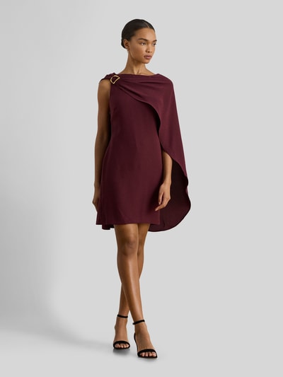 Vrouwenmodel draagt Tailliertes Cocktailkleid mit Umhang van Lauren Ralph Lauren, effen bordeauxrood, getailleerde fit, mini-lengte, boothals, metalen accenten, onzichtbare ritssluiting, mouwloos, zonder zakken, volledige lichaamsweergave van voren.