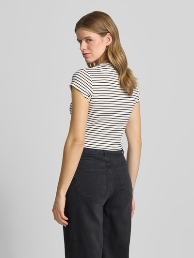 Kobiece model prezentuje Cropped T-Shirt mit Streifenmuster und Logo od Calvin Klein Jeans, mieszanka bawełny i elastanu, wzór w paski, logo, krój krótki, okrągły dekolt, długość tyłu w rozmiarze S: 39 cm, całkowity widok z tyłu.