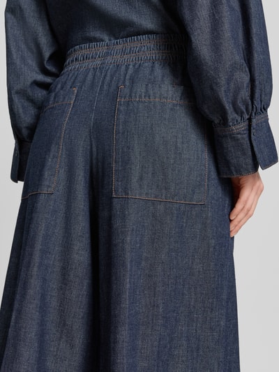 Frauenmodel trägt Wide Leg Jeans mit elastischem Bund Modell 'CEILING' von Drykorn aus reiner Baumwolle in dunklem Blau, Detailaufnahme Rückansicht, sichtbare Struktur, Bundweite bei Größe 27/34: 35 cm, Innenbeinlänge: 78 cm.