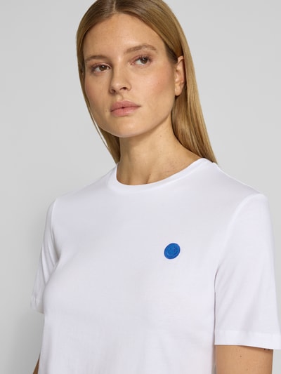 Vrouwenmodel draagt Regular Fit t-shirt uit puur katoen model 'LUALAA EMBRO' van Armedangels, look: effen, labelopschrift, ronde hals, korte mouw, fijnrib materiaalverwerking, Nahaufnahme bovenlichaam.