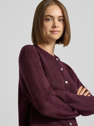 Frauenmodel trägt Loose Fit Strickjacke mit Rundhalsausschnitt Modell 'SIMONI' von ONLY in dunklem Lila, Nahaufnahme Oberkörper, Damen Strickjacke von ONLY