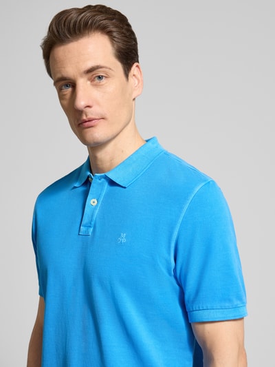 Männermodel trägt Regular Fit Poloshirt aus reiner Baumwolle von Marc O'Polo in Unifarbe Blau, Piqué-Struktur, Nahaufnahme Oberkörper.